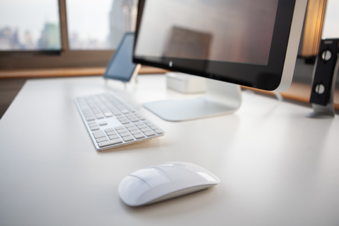 Tidy office desk with a laptop and a clear, organized workspace in a bright office